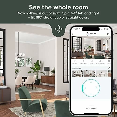 Living room with smart home camera app displayed on smartphone